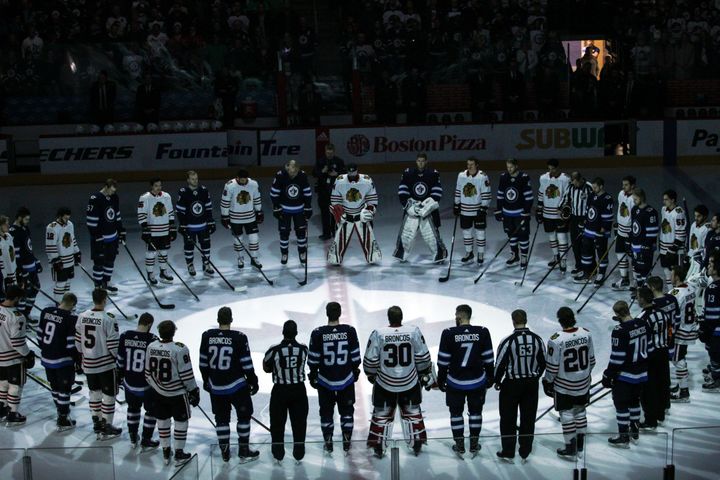 The Winnipeg Jets and Chicago Blackhawks, wearing jerseys reading "Broncos" on their backs, observe a minute of silence for the Humbolt Broncos on Saturday.