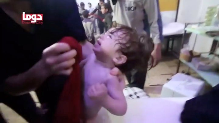 A child cries as they have their face wiped following alleged chemical weapons attack, in what is said to be Douma.