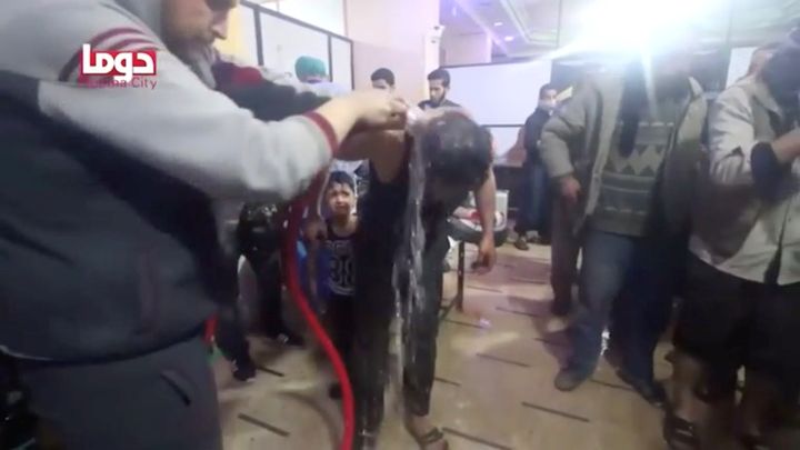 A man is washed following alleged chemical weapons attack, in what is said to be Douma, Syria, in this still image from video obtained by Reuters on April 8, 2018.
