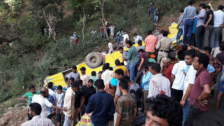 People help to rescue injured after a private school bus falls into a deep gorge in Nurpur, Kangra district, in India on April 9, 2018. (AFP/Getty Images)