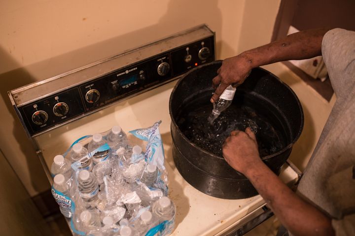 Flint resident Darryl Wilson, 46, heats bottled water so he can wash the dishes on Feb. 18, 2016.