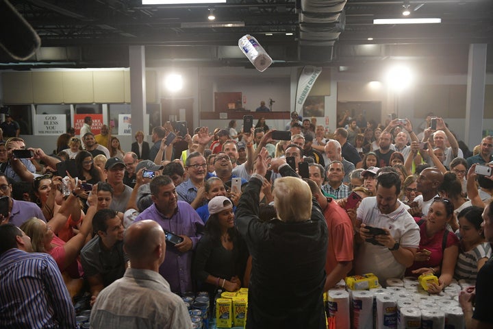 President Donald Trump throws a paper towel roll as he visits the Cavalry Chapel in Guaynabo, Puerto Rico, on Oct. 3, 2017.