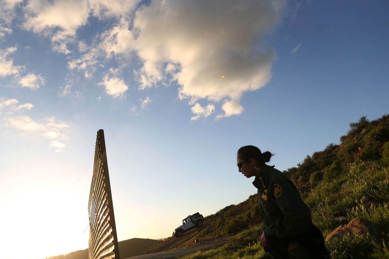 An officer of the U.S. Border Patrol inspects the area where the border fence separating Mexico and the U.S. is interrupted on Feb. 23, 2017.
