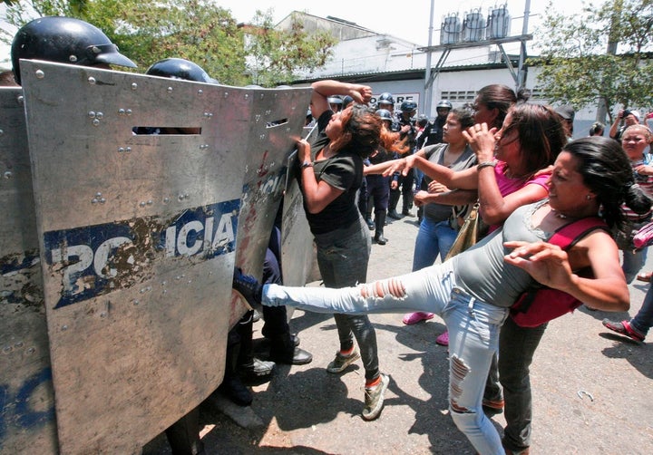 Families clashed with security forces outside the police station in Valencia, Venezuela, where nearly 70 prisoners died in a
