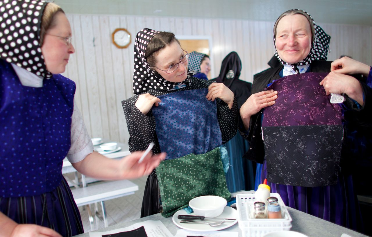 Hutterite women choose fabric to sew into garments.