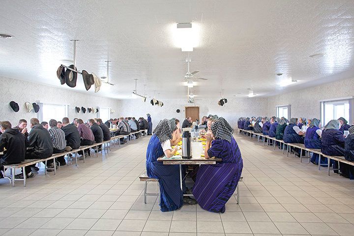 Members of a Hutterite colony eat a communal dinner segregated by gender.