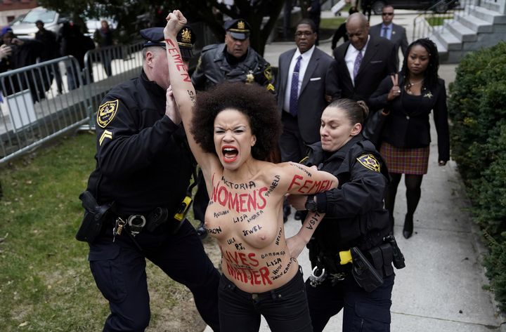 Police hold back protester Nicolle Rochelle in front of the Montgomery County Courthouse in Norristown, Pennsylvania, on April 9, 2018.