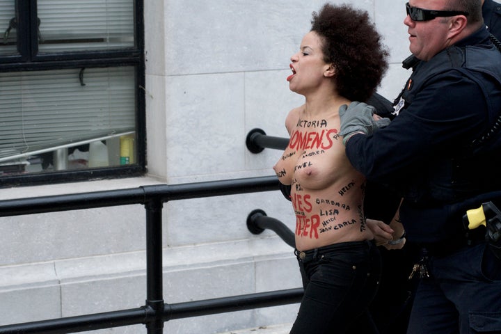 Police take Nicolle Rochelle away from the courthouse after she charged at Bill Cosby on Monday.