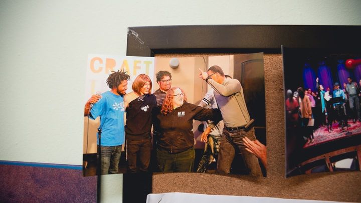 A photo hanging in Kate Barnhart's office of her and some members of New Alternatives at an event for the organization Craft Your Truth.