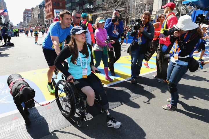 Downes and Kensky celebrate at the finish line with their dog after Downes completed the 120th Boston Marathon in 2016.