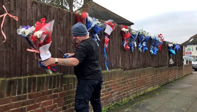 A man removes the flowers from the fence line in the days before Gordon did so