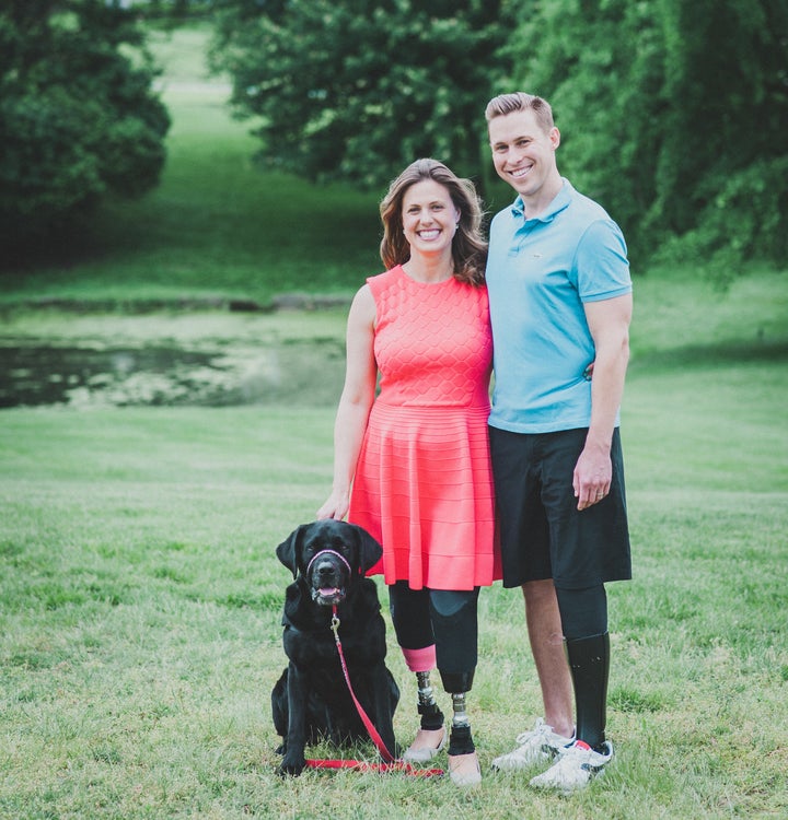 Jessica Kensky and Patrick Downes, who lost three legs between them in the blasts, pose with their support dog, Rescue.