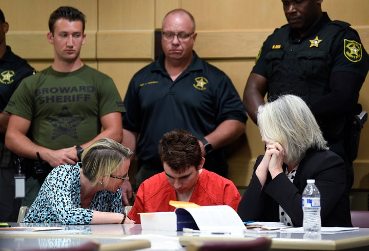 Nikolas Cruz sits with attorneys Melisa McNeill (left) and Diane Cuddihy (right), appointed by the Broward Public Defender's Office, on April 11. 