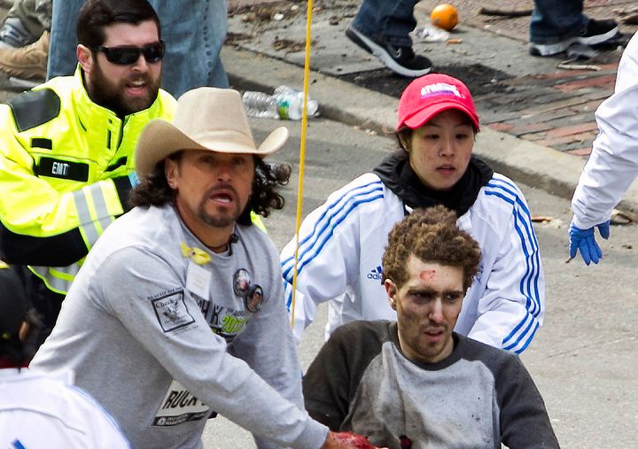 Carlos Arredondo, wearing a cowboy hat, and other people tend to survivor Jeff Bauman in the moments after the blasts near the Boston Marathon finish line on April 15, 2013.