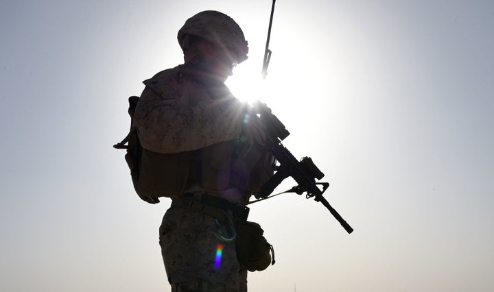 A U.S. Marine watches Afghan Commandos take part in a combat training exercise at Shorab Military Camp in Helmand, Afghanistan, in August 2017.