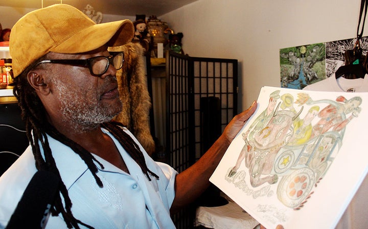 Reinaldo Sanchez shows one of his pieces of artwork depicting police violence.