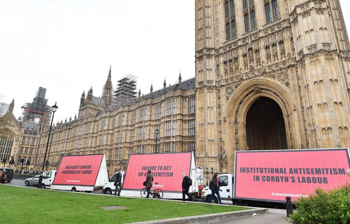 A convoy of three billboard advertising vans with message for Jeremy Corbyn and the Labour party, pass by the Houses or Parliament in London ahead of Tuesday's debate.