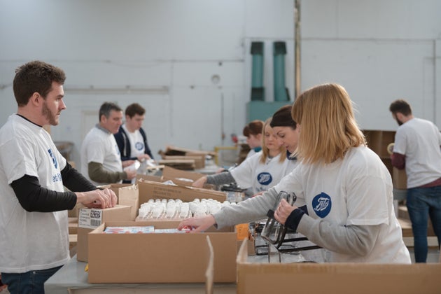 Volunteers packing wash bags in the Boots warehouse.