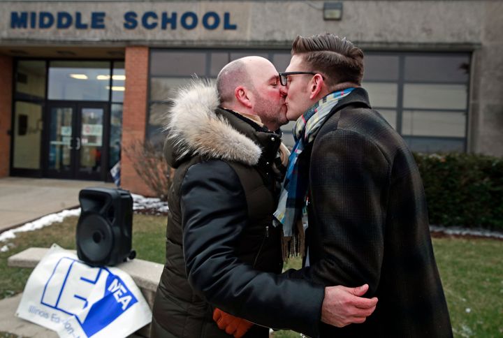 Teacher Nathan Etter, right, kisses his husband, Philip Etter, during a Monday rally in Burlington, Illinois, in support of the educator.