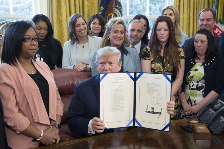President Donald Trump holds up a signed sex trafficking bill targeting online platforms at the White House on April 11. 