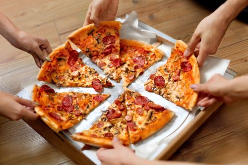 People enjoying pizzas with various toppings