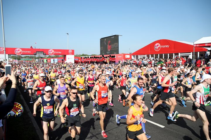 Runners makes his way past the video screen of Queen Elizabeth II during the 2018 Virgin Money London Marathon