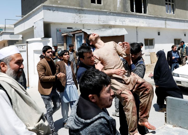 Relatives of victims carry an injured man outside a hospital after a suicide attack in Kabul, Afghanistan, on April 22, 2018. (REUTERS/Mohammad Ismail)