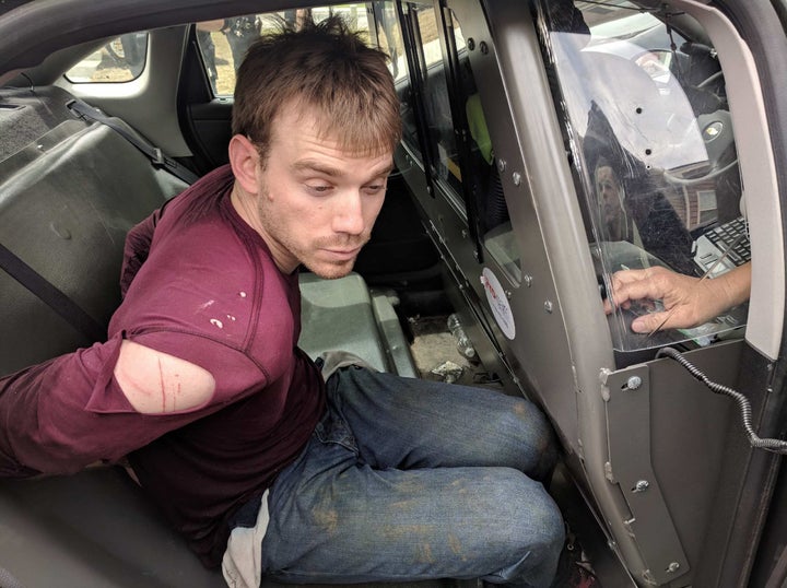 In this handout provided by the Metro Nashville Police Department, Travis Reinking, 29, is placed in the back of a police car