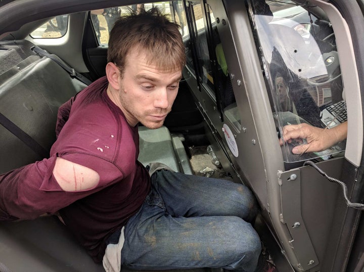 In this handout provided by the Metro Nashville Police Department, Travis Reinking, 29, is placed in the back of a police car after being arrested on April 23 in Nashville, Tennessee.