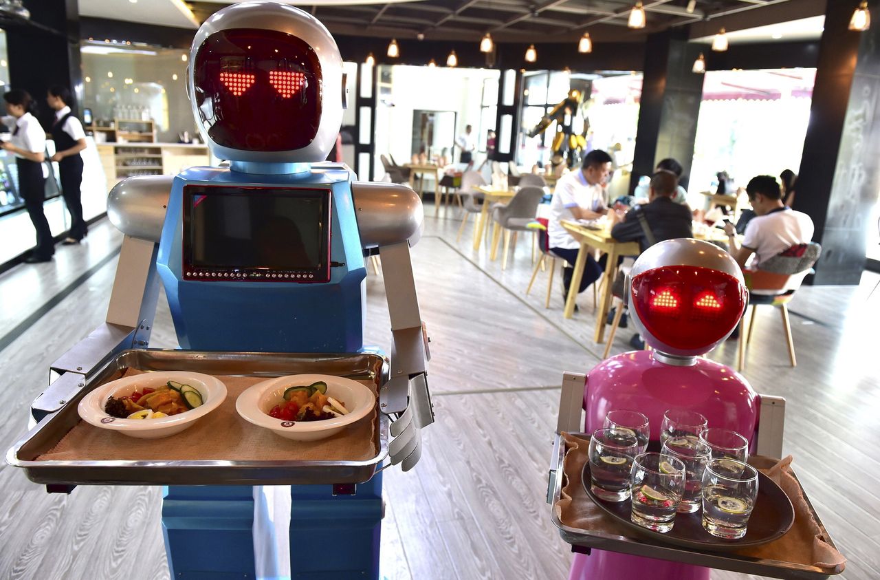 Robots known as Xiaolan (L) and Xiaotao serve customers at a restaurant in Jinhua, Zhejiang province, China.