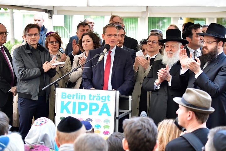 Berlin's mayor Michael Mueller (C) speaks during the