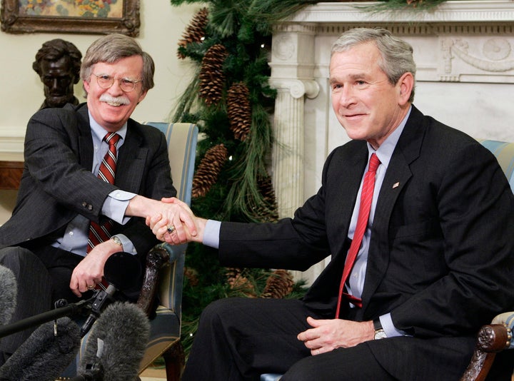 Bush's United Nations representative John Bolton shakes hands with the president in 2006. Bolton is now advising President Donald Trump on national security.