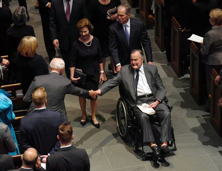 Former President George H.W. Bush is seen exiting the funeral services of his wife, Barbara, followed by his daughter-in-law, former first lady Laura Bush, and son, former President George W. Bush.