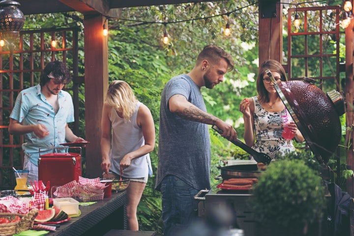 Friends during a summer day, doing barbecue in the pergola