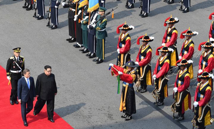 Moon walks Kim along a red carpet into South Korean territory, where school children placed flowers around their necks and an honour guard stood at attention for inspection