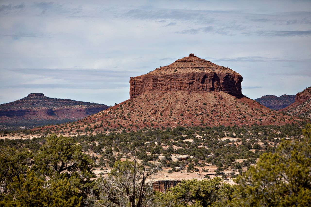 TOP PHOTO: Chris D'Angelo, environmental reporter for HuffPost, walks through land that was formerly part of Bears Ears National Monument. ABOVE: Cheese Box Butte, formerly part of the national monument.