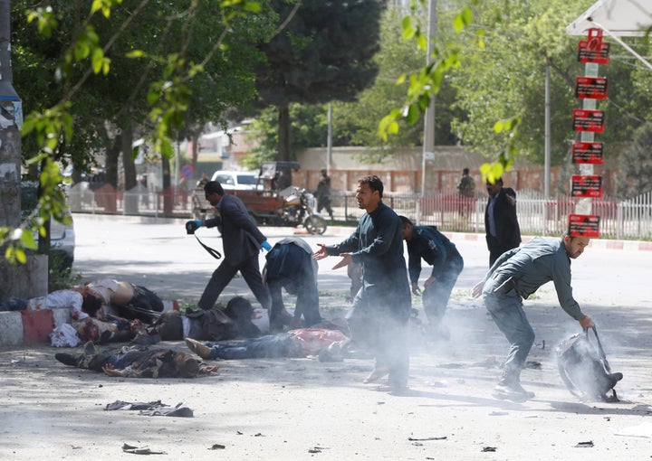 Police officers help journalists who were injured in the second Kabul blast on Monday, April 30, 2018.