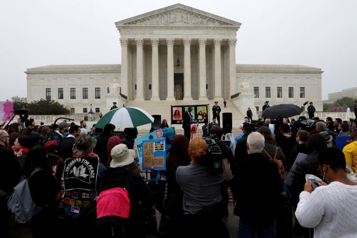 Protesters gather outside the U.S. Supreme Court, while the court weighs the legality of President Donald Trump's latest travel ban targeting people from Muslim-majority countries on April 25.