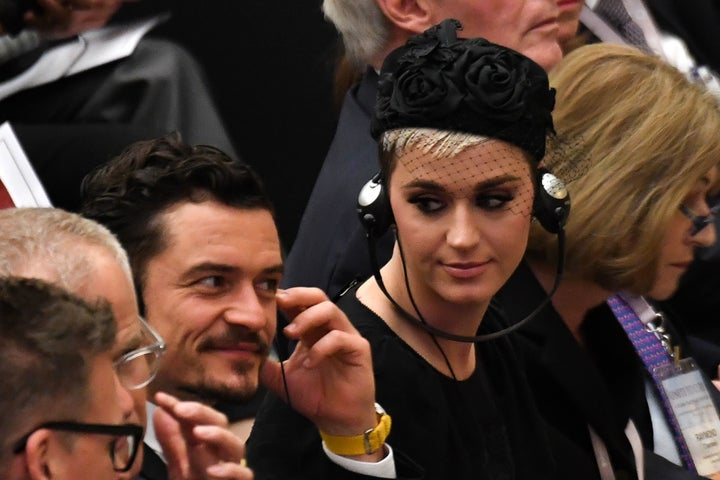 Katy Perry looks toward British actor Orlando Bloom as they listen via headphones to a translation of Pope Francis' spee