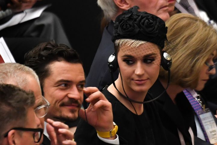 Katy Perry looks toward British actor Orlando Bloom as they listen via headphones to a translation of Pope Francis' speech to participants at the Unite To Cure conference at the Vatican on April 28.