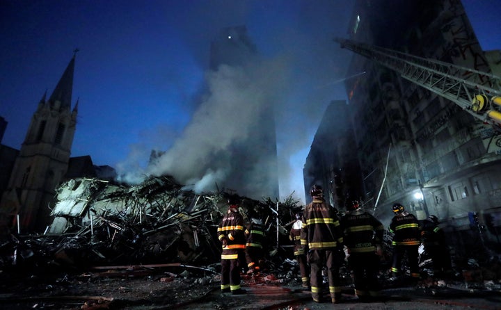 Firefighters stand by outside a site of building collapsed in downtown Sao Paulo, Brazil, May 1.