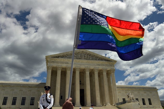 &nbsp;A supporter of gay marriage waves his rainbow flag in front of the U.S. Supreme Court in Washington,...