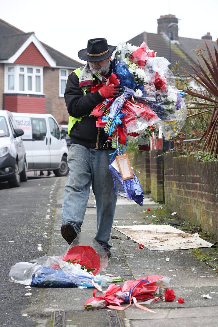 <strong>Iain Gordon kicks flowers as he takes them away from the scene near the house of Richard Osborn-Brooks in South Park Crescent in Hither Green</strong>