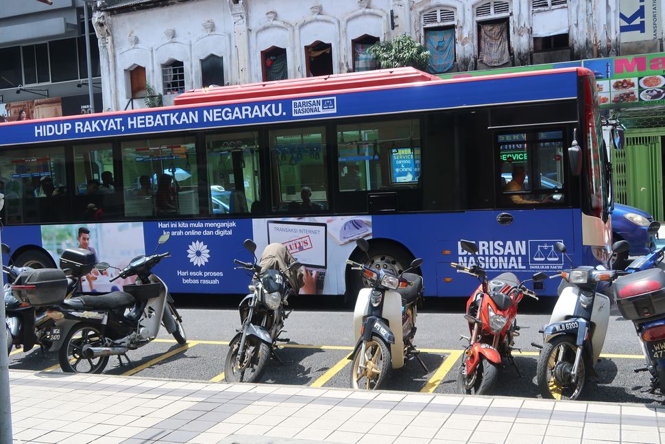 Election signs are displayed on a bus in Kuala Lumpur. The May 9 election is the first midweek contest in the country since its first election in 1959.