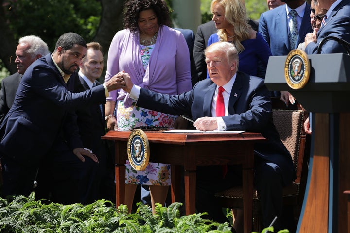 Pastor Darrell Scott and President Donald Trump shake hands at the the National Day of Prayer ceremony in the White House Rose Garden.