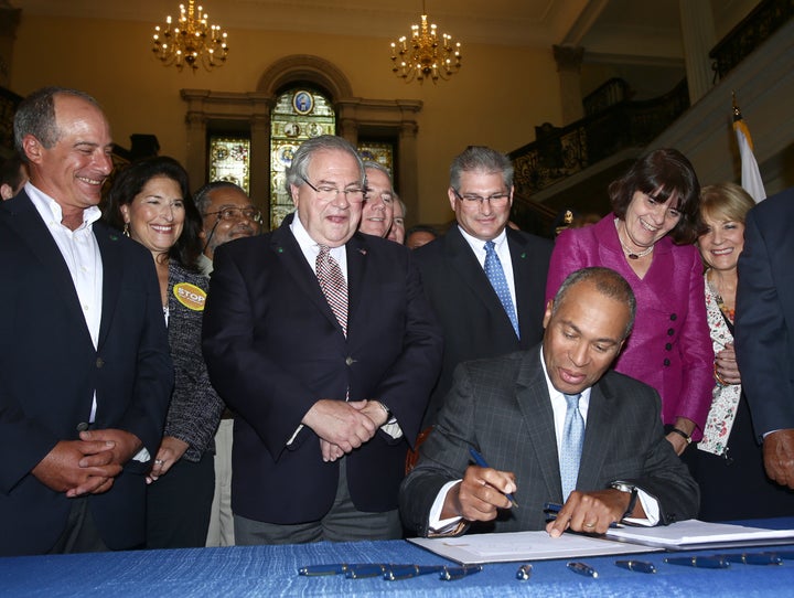 Deval Patrick, former governor of Massachusetts, signs a 2014 gun violence bill while Robert DeLeo, the House Speaker, looks on. That measure&nbsp;made the state's laws, already among&nbsp;nation's strongest, even stronger.