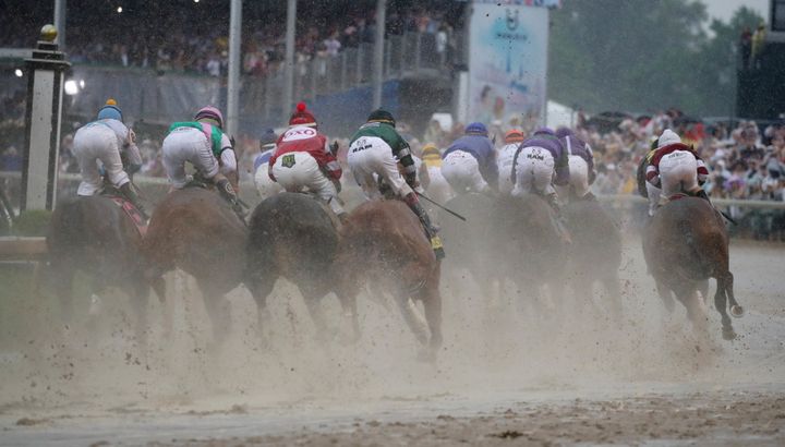 Horses make their way around the first turn during the 144th running of the Kentucky Derby at Churchill Downs.