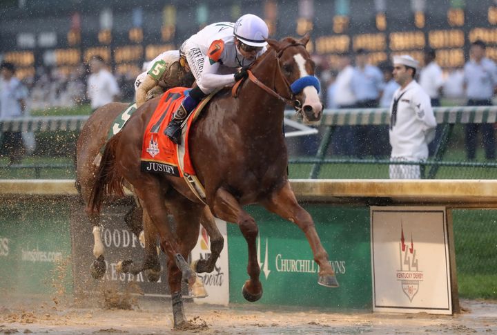 Justify crosses the finish line to win.