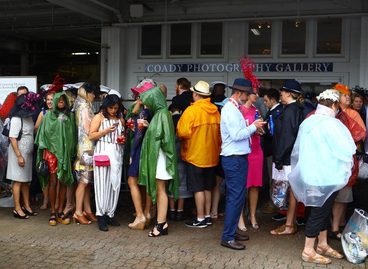 Horse racing fans seek shelter from the rain at Saturday's race.