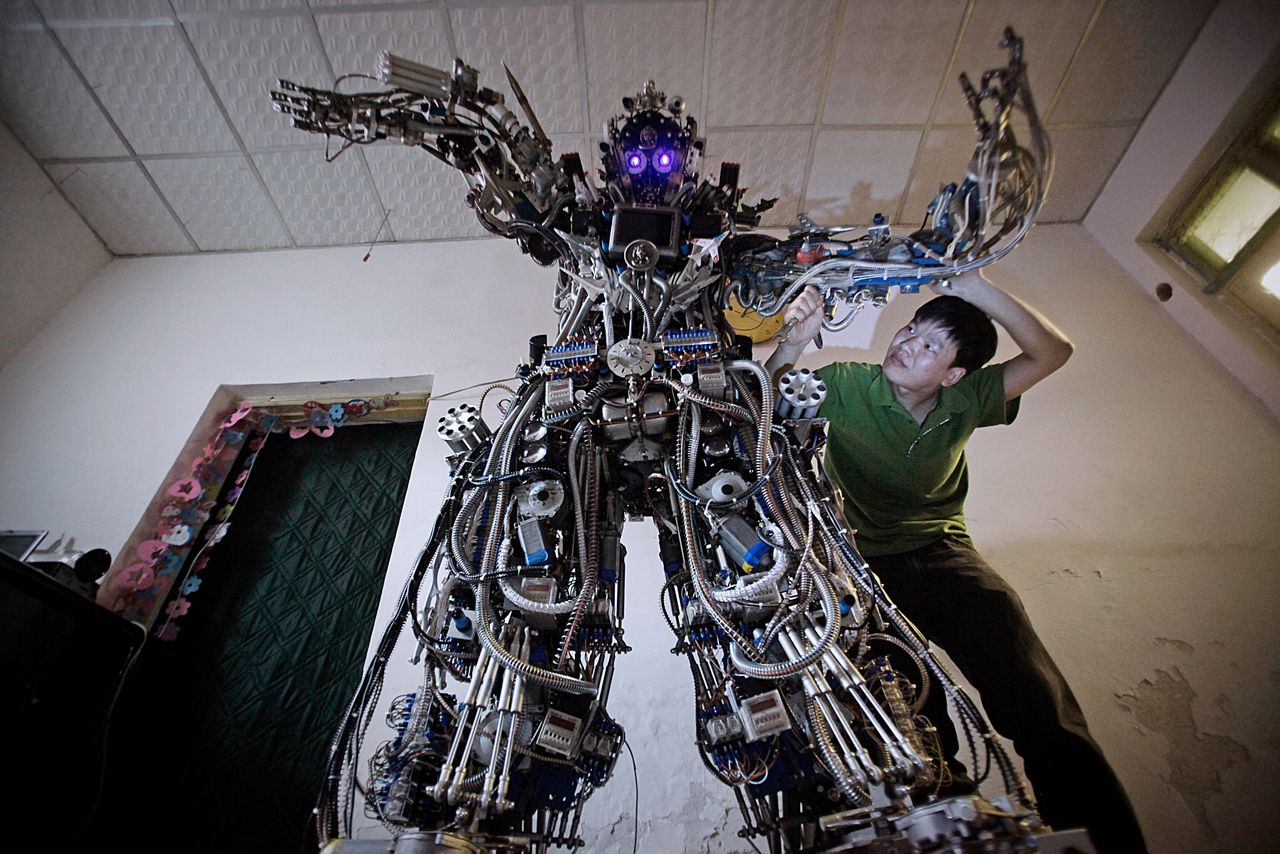 Ο Κινέζος εφευρέτης Tao Xiangil καθώς προχωρά σε αλλαγές στα κυκλώματα του ρομπότ που δημιούργησε στο σπίτι του στη Beijing